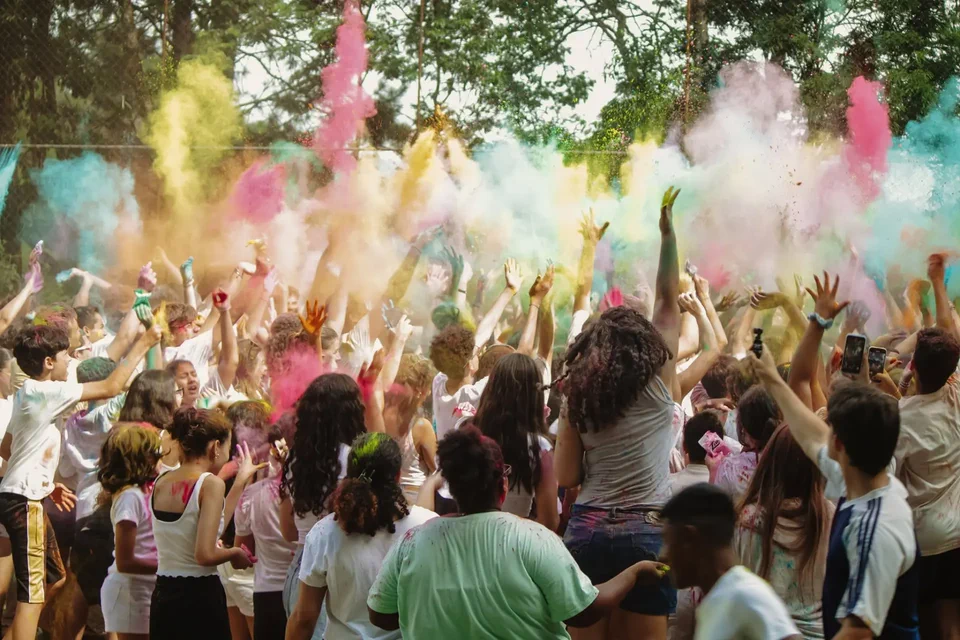 Jovens reunidos em uma celebração com pó colorido no acampamento